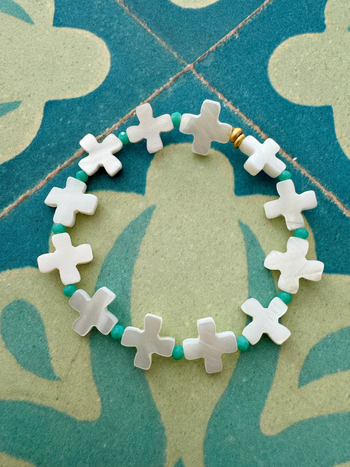 Handcrafted ocean inspired St Jean Bracelet featuring mother of pearl crosses and sea green beads, perfect for summer stacking.