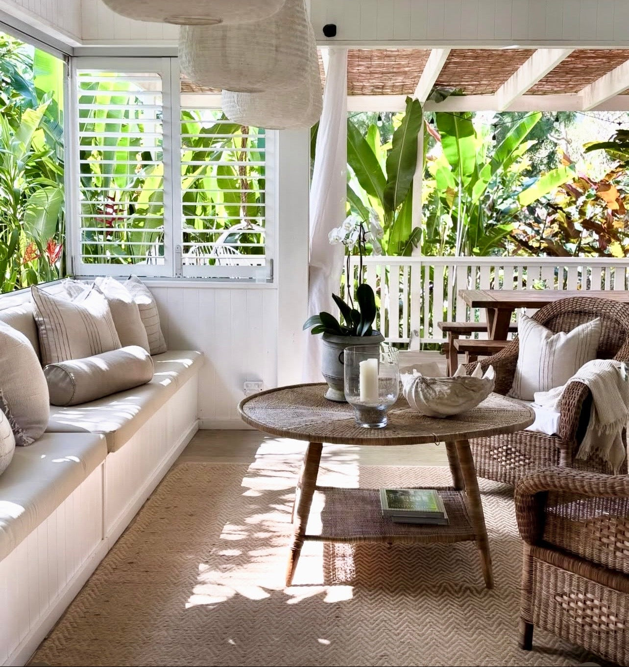 Living room with white walls, wooden furniture, and plants