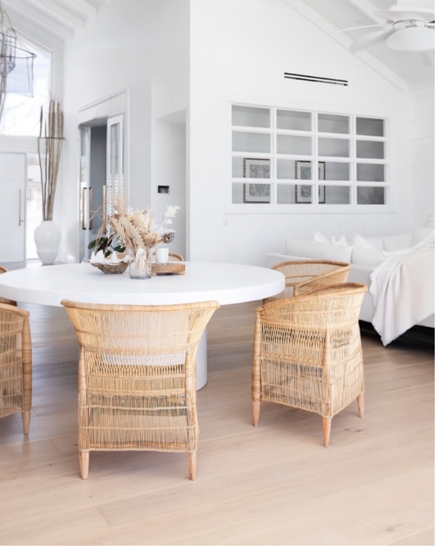 Modern interior with a round white table and Malawi Chairs in a bright room.