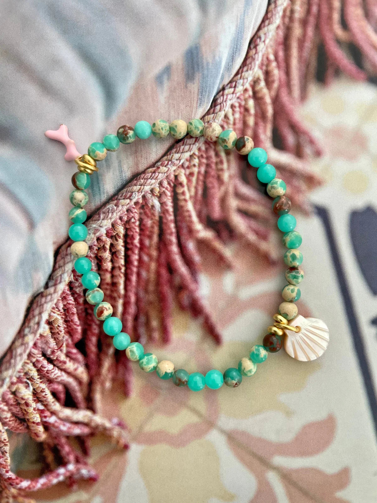 Handcrafted ocean inspired jewelry featuring a Boca Chica Bracelet with pink and sea green jasper beads and charm details.