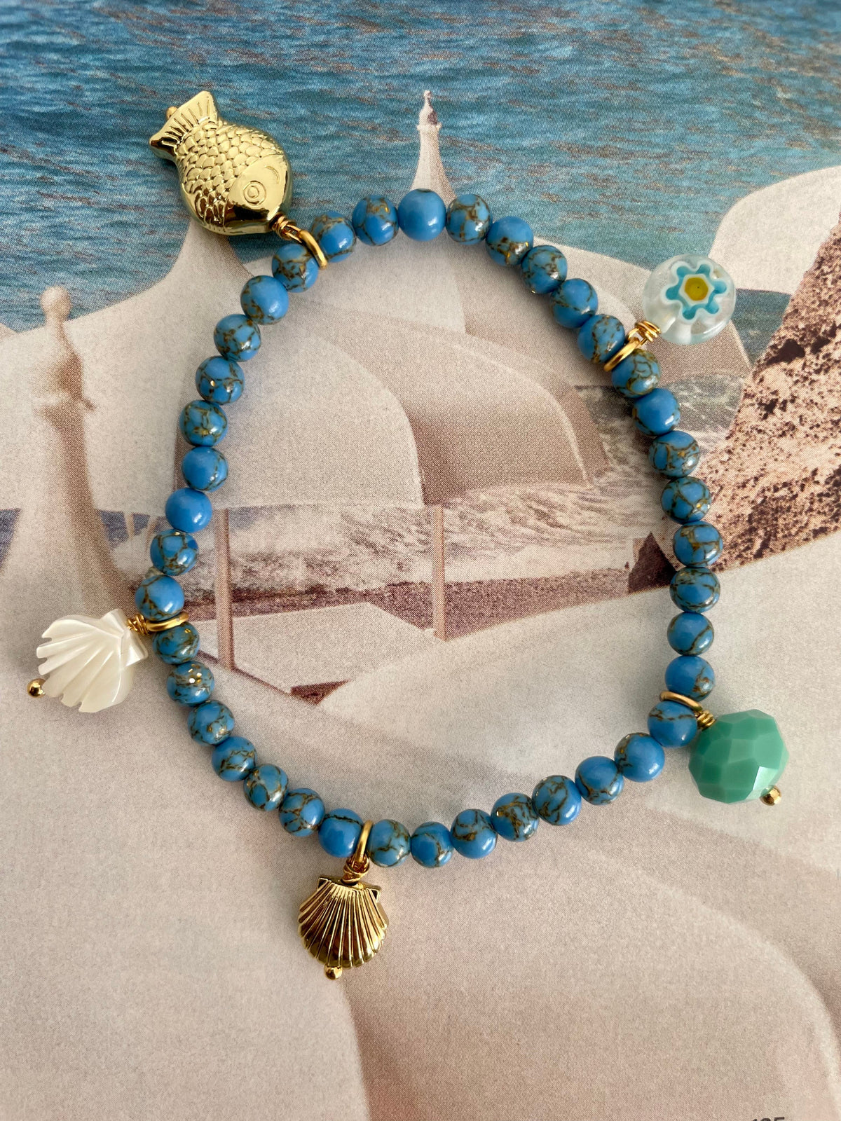 Handcrafted ocean-inspired jewelry featuring Sirena Bracelet with sea sediment jasper beads and gold fish charm.