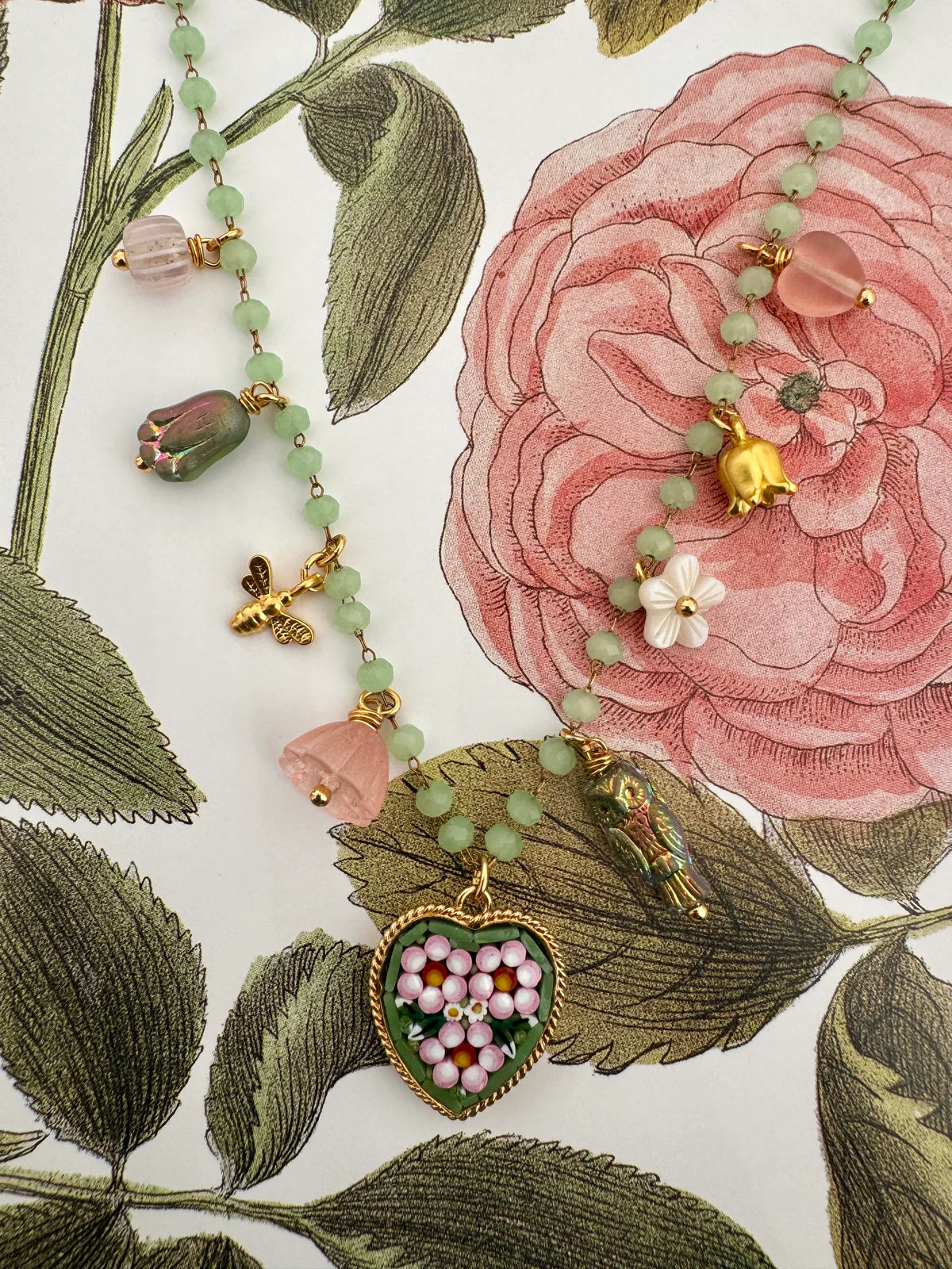 Handcrafted Florian Heart Necklace featuring micro mosaic floral pendant on a pink and green nature-inspired background.