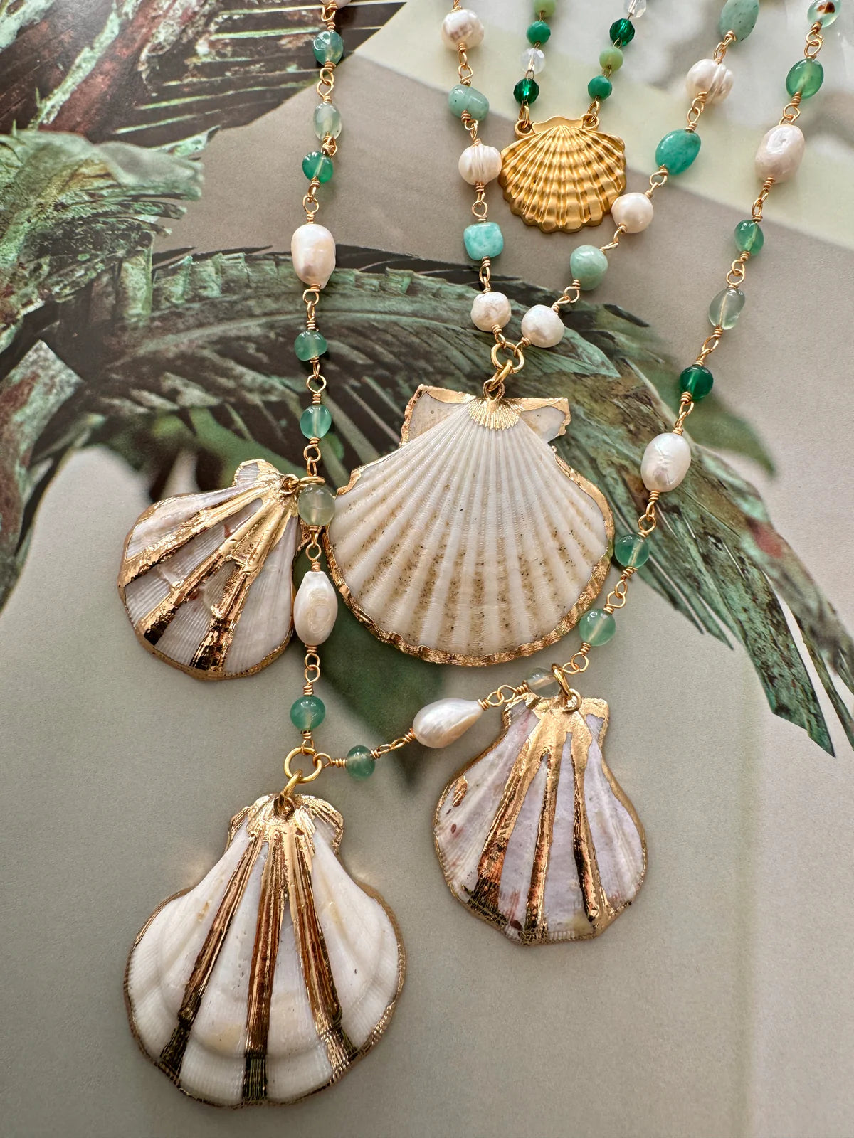 Handcrafted ocean-inspired Sapore di Mare Necklace with gold-plated shells, jade, and freshwater pearls on a layered chain.