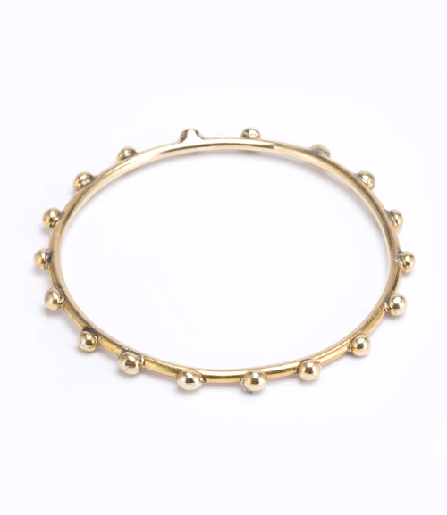 Gold bracelet with bead-like accents on a white background