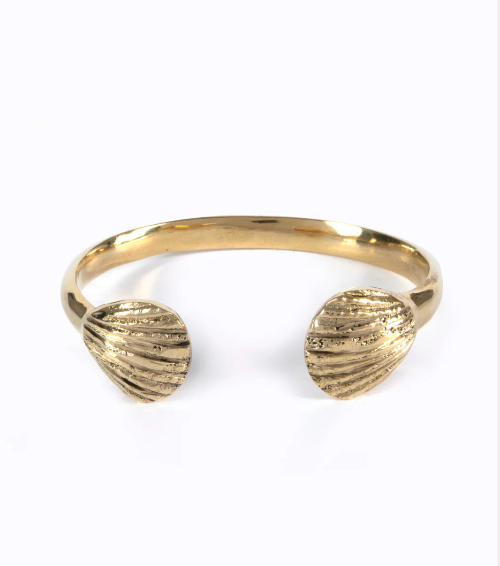 Gold bracelet with shell-like ends on a white background
